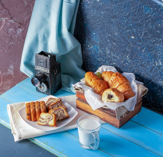 Cornetti con crema al cioccolato, torta alla vaniglia e un bicchiere di latte.