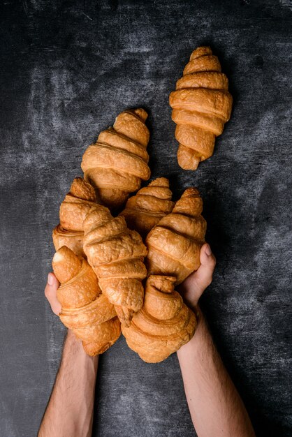 cornetti in mano sul tavolo grigio.