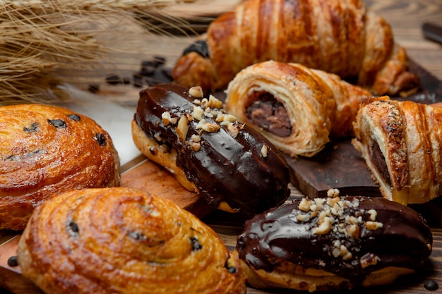 Cornetto di pasta sfoglia al cioccolato, eclair al cioccolato e rotolo di uva passa dolce