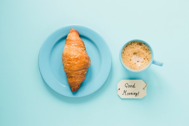 Cornetto piatto sul piatto con caffè