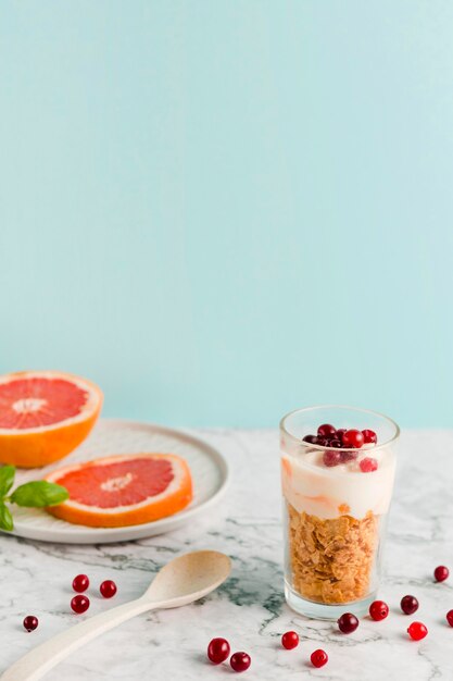 Cornflakes ad alto angolo con yogurt e agrumi in vetro