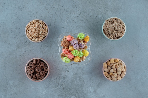 Cornflakes in un bicchiere di caffè al latte e ciotole, sullo sfondo blu. Foto di alta qualità