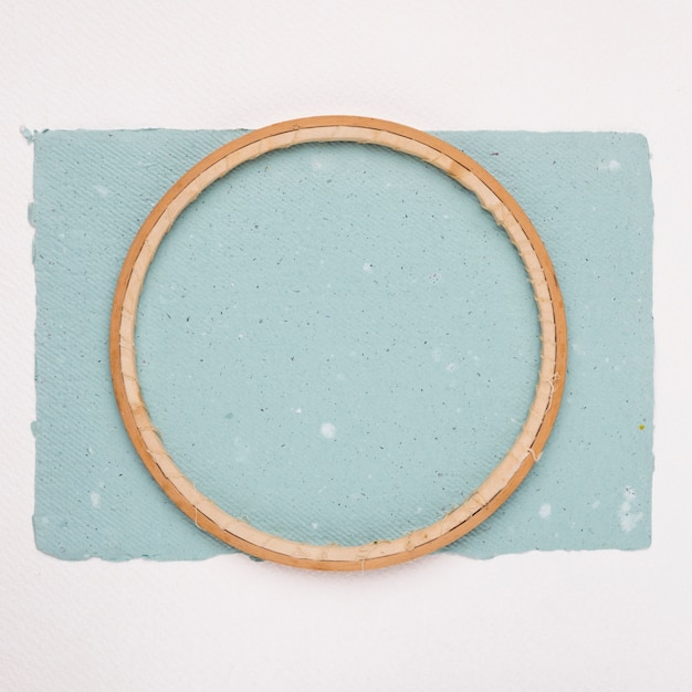 Cornice circolare in legno su carta blu su sfondo bianco