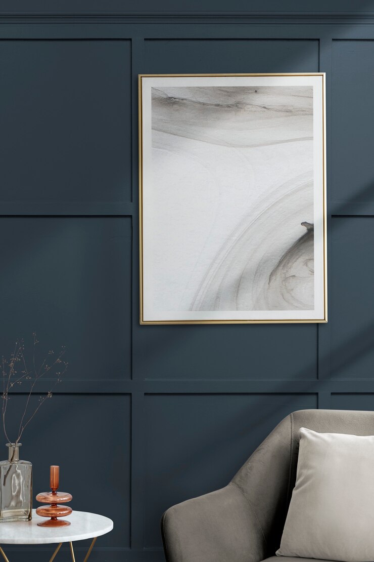 Foto gratuito cornice con arte astratta da una poltrona di velluto grigio