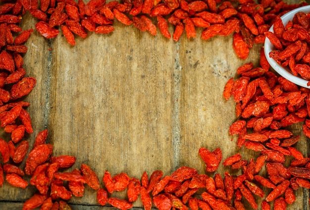 Cornice di bacche di Goji su una tavola di legno