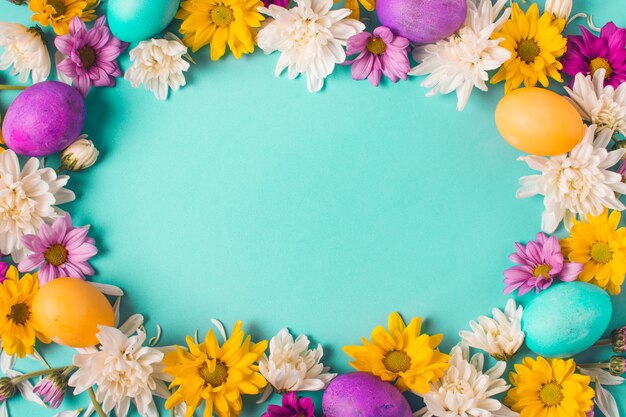 Cornice di uova luminose e boccioli di fiori