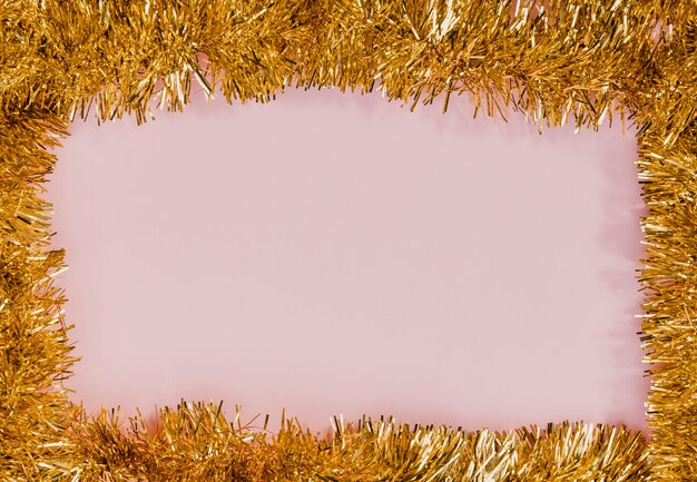 Cornice dorata tinsel con sfondo rosa