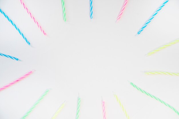 Cornice vuota con candele colorate strisce su sfondo bianco