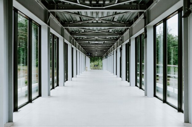 Corridoio bianco con porte in vetro e soffitto in metallo in un edificio moderno
