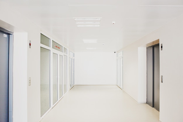 Corridoio dell'ospedale vuoto con porte in vetro