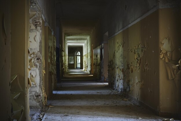 Corridoio di un edificio abbandonato con pareti invecchiate sotto le luci