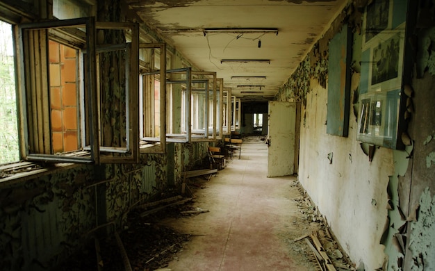 Corridoio scolastico abbandonato con finestre aperte nella zona della città fantasma di radioattività di Chernobyl