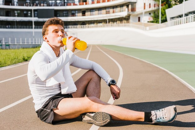 Corridore che beve una bevanda energetica