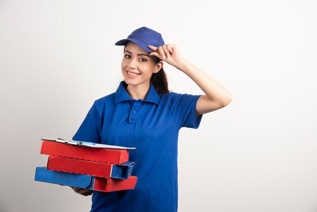 Corriere donna con cartone di pizza e appunti. Foto di alta qualità