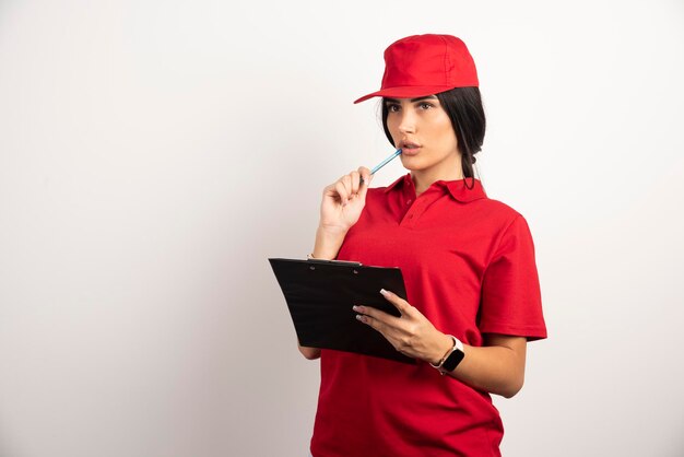 Corriere femminile in uniforme rossa che pensa a qualcosa. Foto di alta qualità