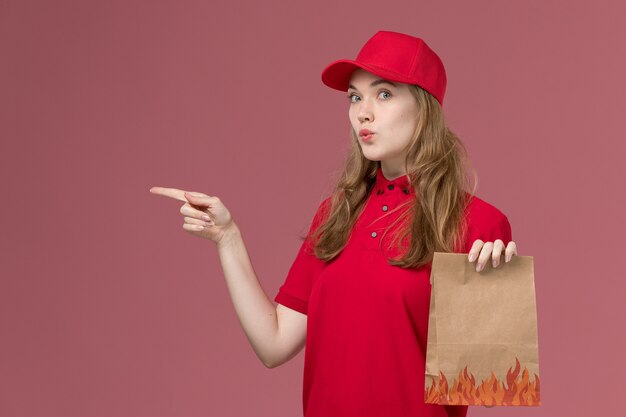 corriere femminile in uniforme rossa che tiene il pacchetto di cibo in rosa, lavoratore di lavoro di consegna del servizio uniforme