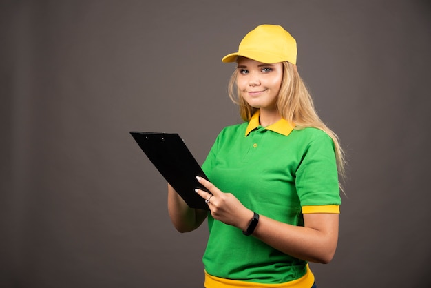 Corriere femminile sorridente con matita e appunti.