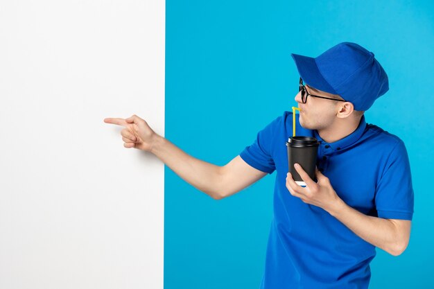 Corriere maschio di vista frontale che beve caffè su un blu