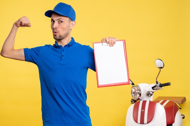 Corriere maschio di vista frontale che tiene la nota del file sull'emozione del lavoro della bici dell'uniforme del lavoratore di colore giallo