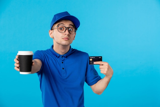 Corriere maschio di vista frontale con caffè e carta di credito sull'azzurro