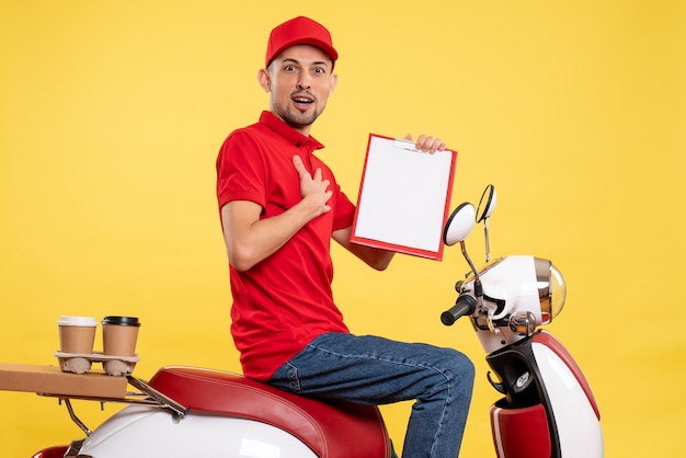 Corriere maschio di vista frontale in uniforme rossa con la nota di file sul lavoro di servizio del lavoratore dell'uniforme del lavoro della bici di consegna di colore giallo