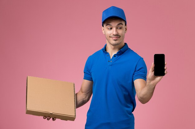 corriere maschio in uniforme blu che tiene il telefono della scatola di cibo di consegna sulla consegna rosa, uniforme del servizio del lavoratore di lavoro