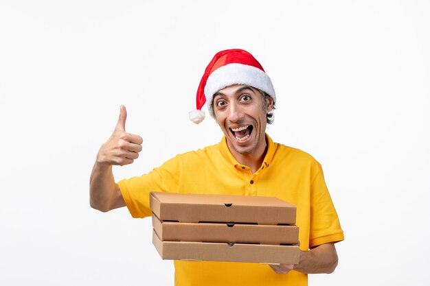 Corriere maschio vista frontale con scatole per pizza su un lavoro di consegna uniforme muro bianco