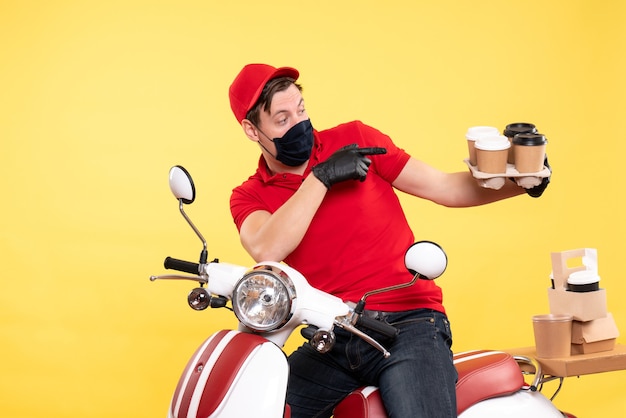 Corriere maschio vista frontale in bici in maschera con caffè su giallo