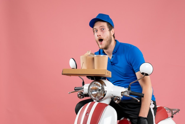 Corriere maschio vista frontale in uniforme blu che tiene scatola di caffè e cibo sul servizio rosa fast-food consegna lavoro lavoro bici colore