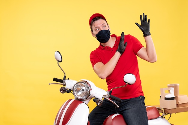 Corriere maschio vista frontale in uniforme rossa e maschera su giallo