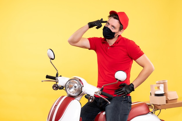 Corriere maschio vista frontale in uniforme rossa e maschera su giallo