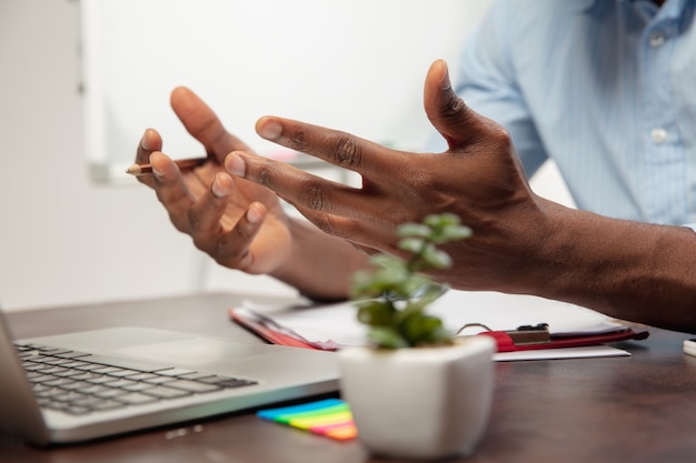 Corsi di inglese online a casa. Chiudere le mani dell'uomo durante l'insegnamento agli studenti in remoto all'interno