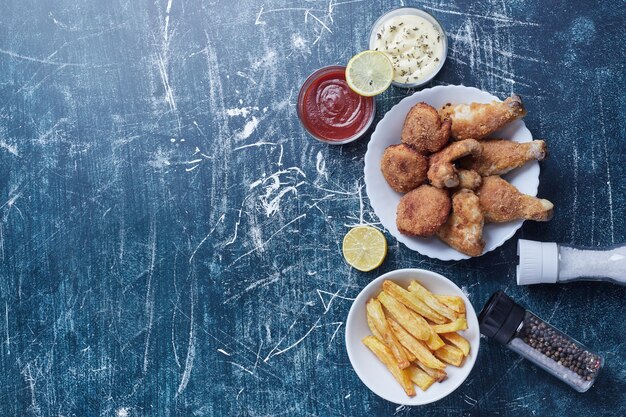 Cosce di pollo croccanti con crocchette e patate.