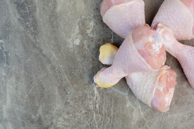 Cosce di pollo crude fresche su fondo di marmo. Foto di alta qualità