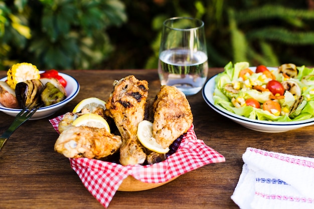 Cosce di pollo e insalata servite all&#39;aperto