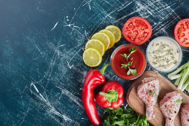 Cosce di pollo su una tavola di legno con salse.