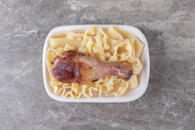 Coscia di pollo al forno sulla pasta, sul marmo.