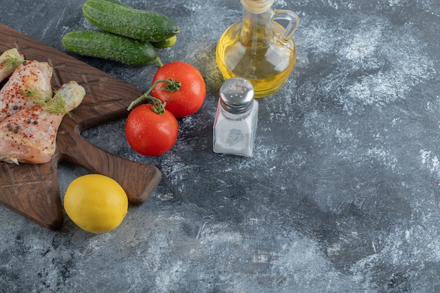 Coscia di pollo crudo e verdure fresche.