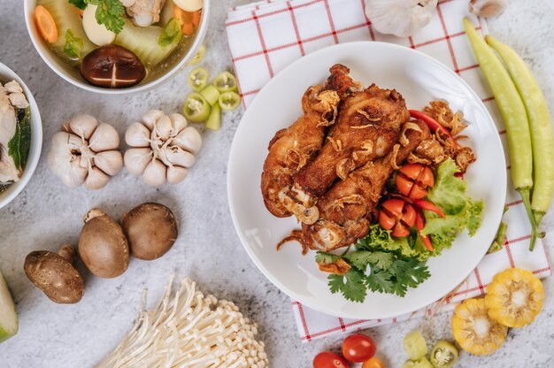 Coscia di pollo fritta con pomodoro, peperoncino, cipolla fritta, lattuga, mais e funghi agugliati.