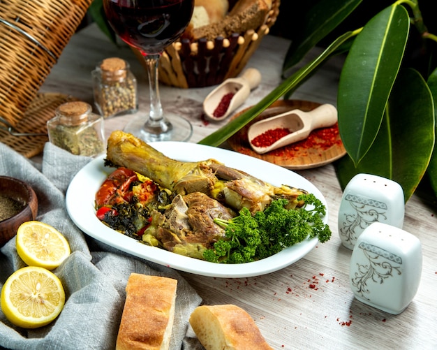 Cosciotto di agnello bollito vista laterale con verdure con spezie fette di pane e pane