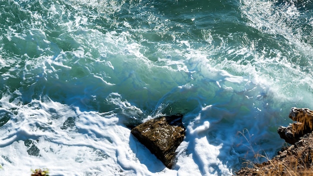 Costa rocciosa del Mar Egeo della Grecia, onde e molta schiuma