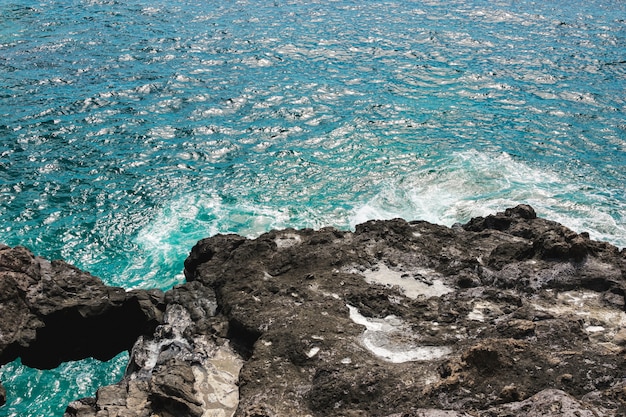 Costa rocciosa del primo piano con acqua cristallina