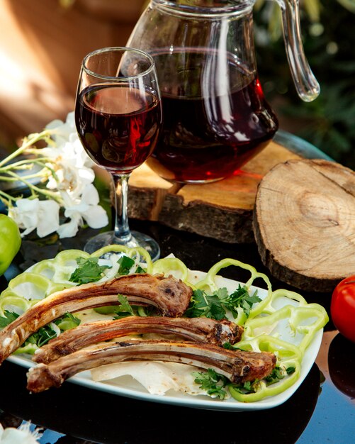 Costolette di agnello servite con peperone, cipolla, erbe e focaccia