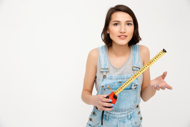 Costruttore di donna felice intelligente, tenere il nastro di misurazione