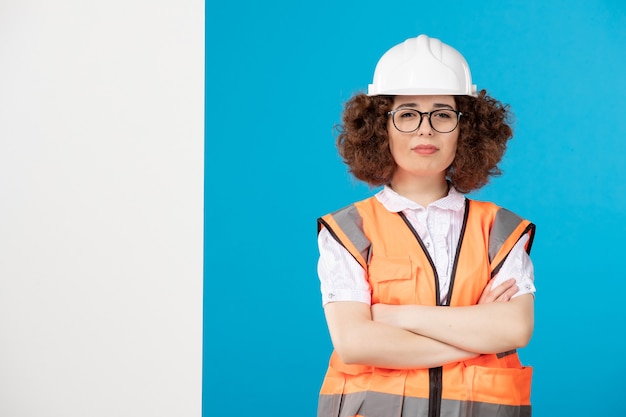 Costruttore femminile di vista frontale in uniforme sull'azzurro