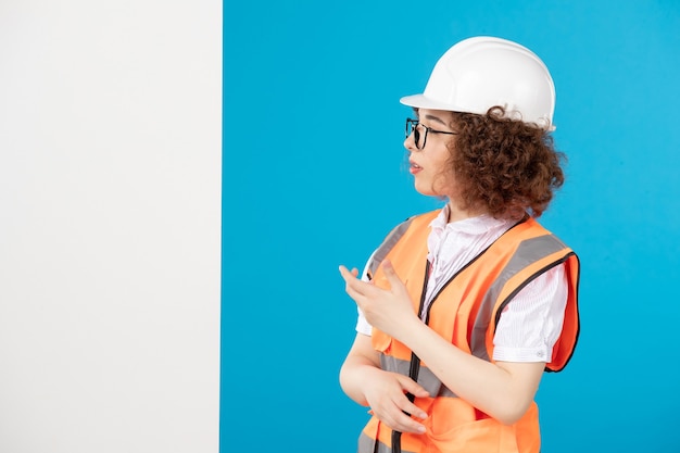 Costruttore femminile di vista frontale in uniforme sull'azzurro