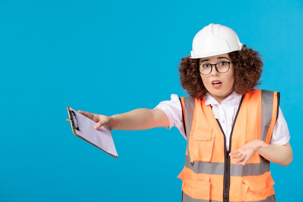 Costruttore femminile nervoso di vista frontale in uniforme sull'azzurro