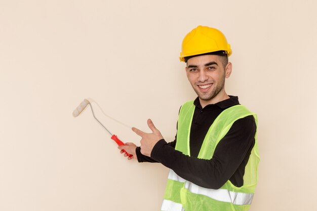 Costruttore maschio vista frontale in muri di pittura casco giallo su sfondo chiaro