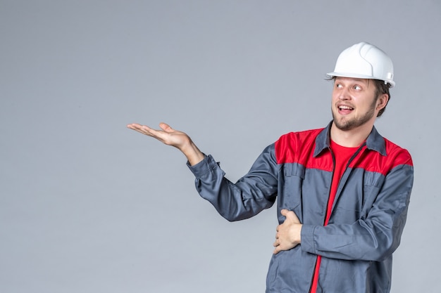 costruttore maschio vista frontale in uniforme e casco su sfondo grigio