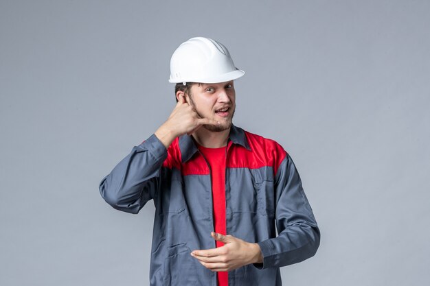 costruttore maschio vista frontale in uniforme e casco su sfondo grigio